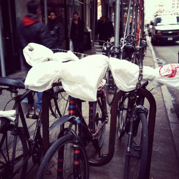 delivery bikes outfitted with plastic bag windbreakers